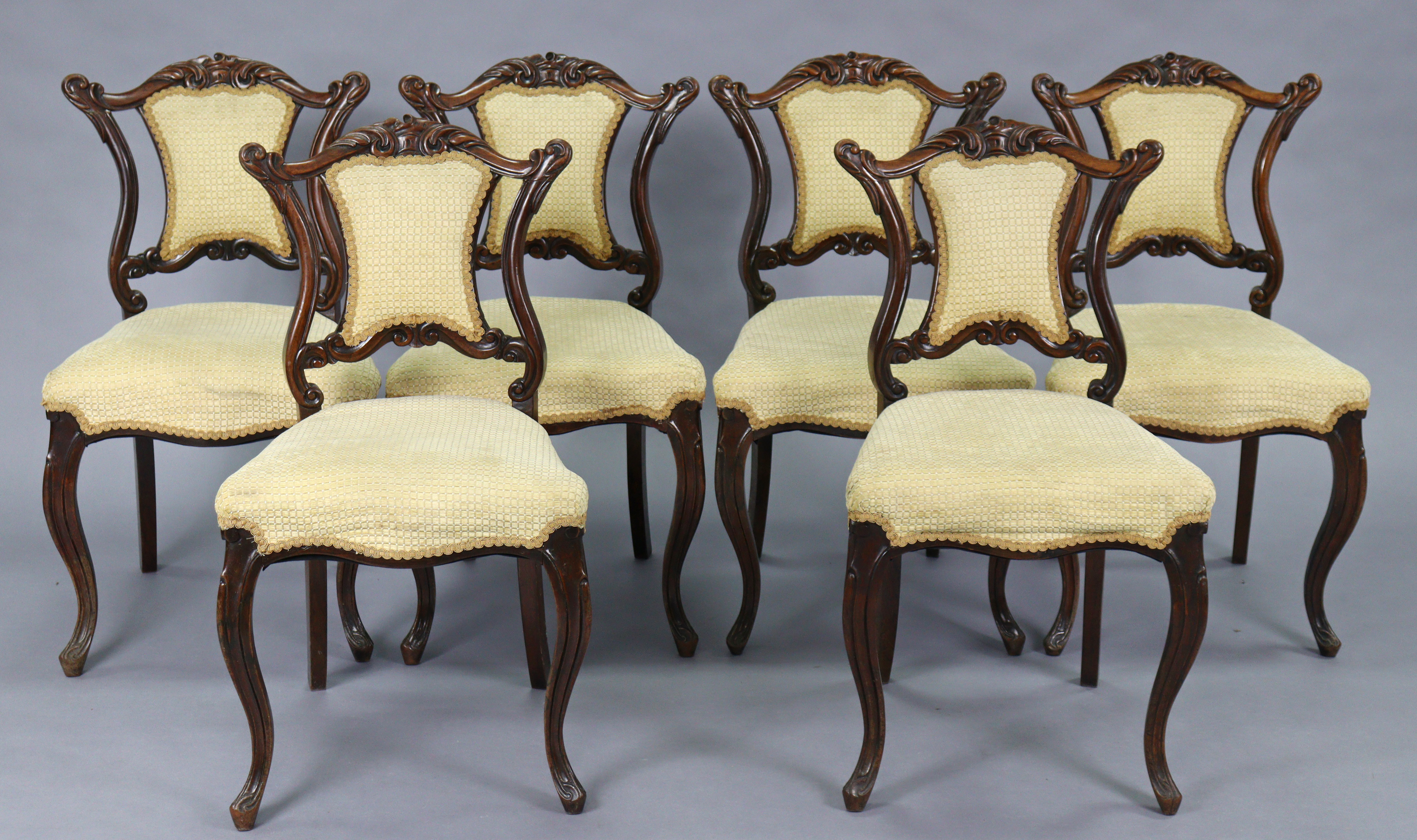 A set of six Victorian rosewood dining chairs with shaped & carved centre rails to the open backs,