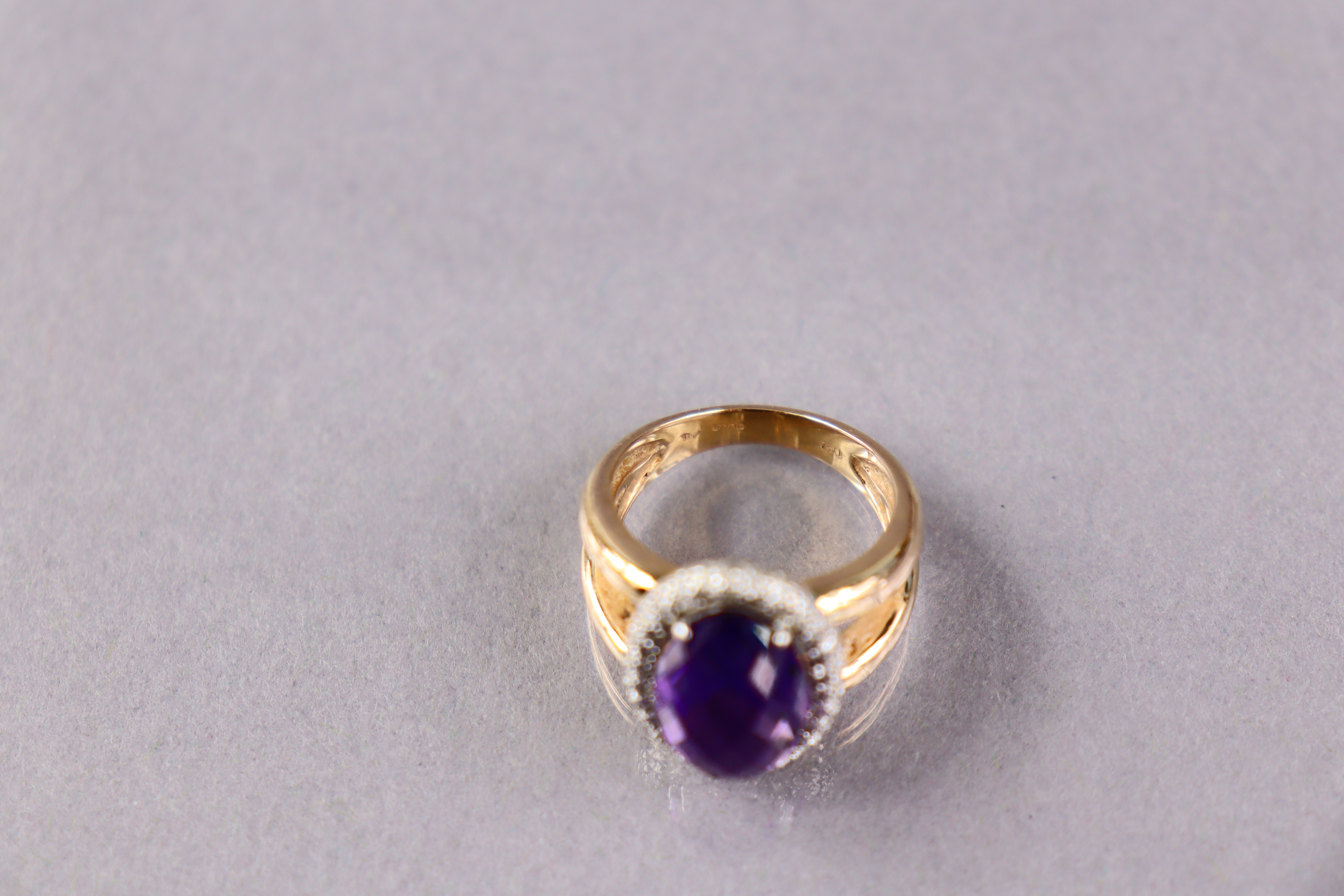 An 18ct gold ring set oval facet-cut amethyst within a border of small diamonds, size M. (7.9g) - Image 3 of 3