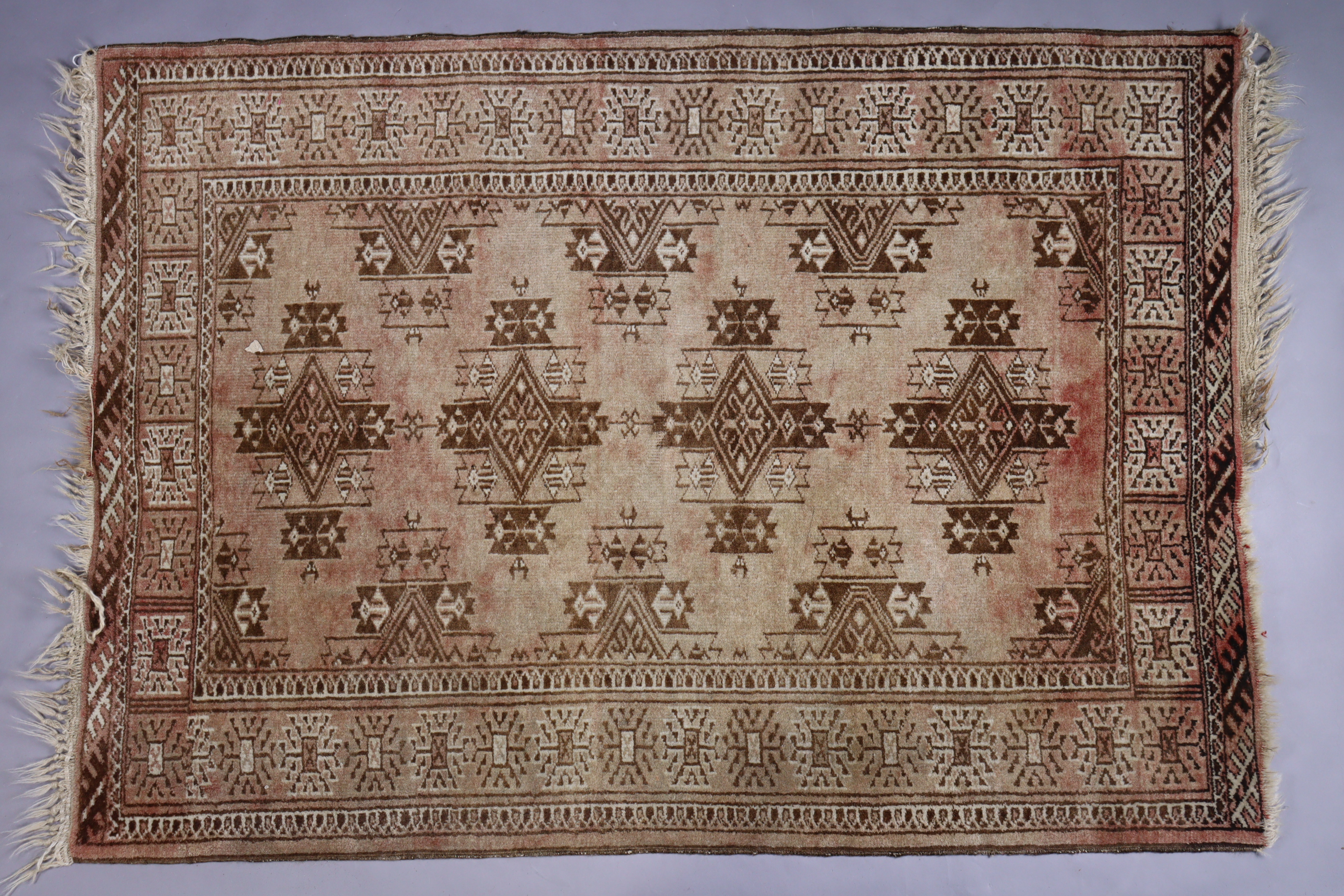 A small Bokhara rug of madder ground, central row of four lozenges within multiple