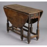 An 18th century oak gate-leg table, fitted end drawers with shaped apron, half-round drop-leaves, on