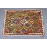 A Chobi kilim rug of ivory ground, the central field with a multicoloured geometric design, in a