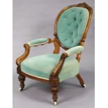 A Victorian spoon-back elbow chair with carved decoration to the beech frame, padded seat, back &