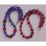 A necklace of facetted ruby beads, 19½”; & another of facetted sapphire & carved ruby beads, 18¾”.