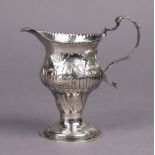A George III silver cream jug of inverted pear shape with embossed decoration of rural scenes, scro