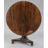 An early Victorian rosewood loo table with circular tilt-top, on tapered centre column & triform