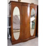 An Edwardian inlaid-mahogany wardrobe with a bow-fronted centre panel flaked by a bevelled oval