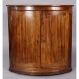 A 19th century inlaid-mahogany large bow-front hanging corner cupboard, fitted two shelves, 36” wide