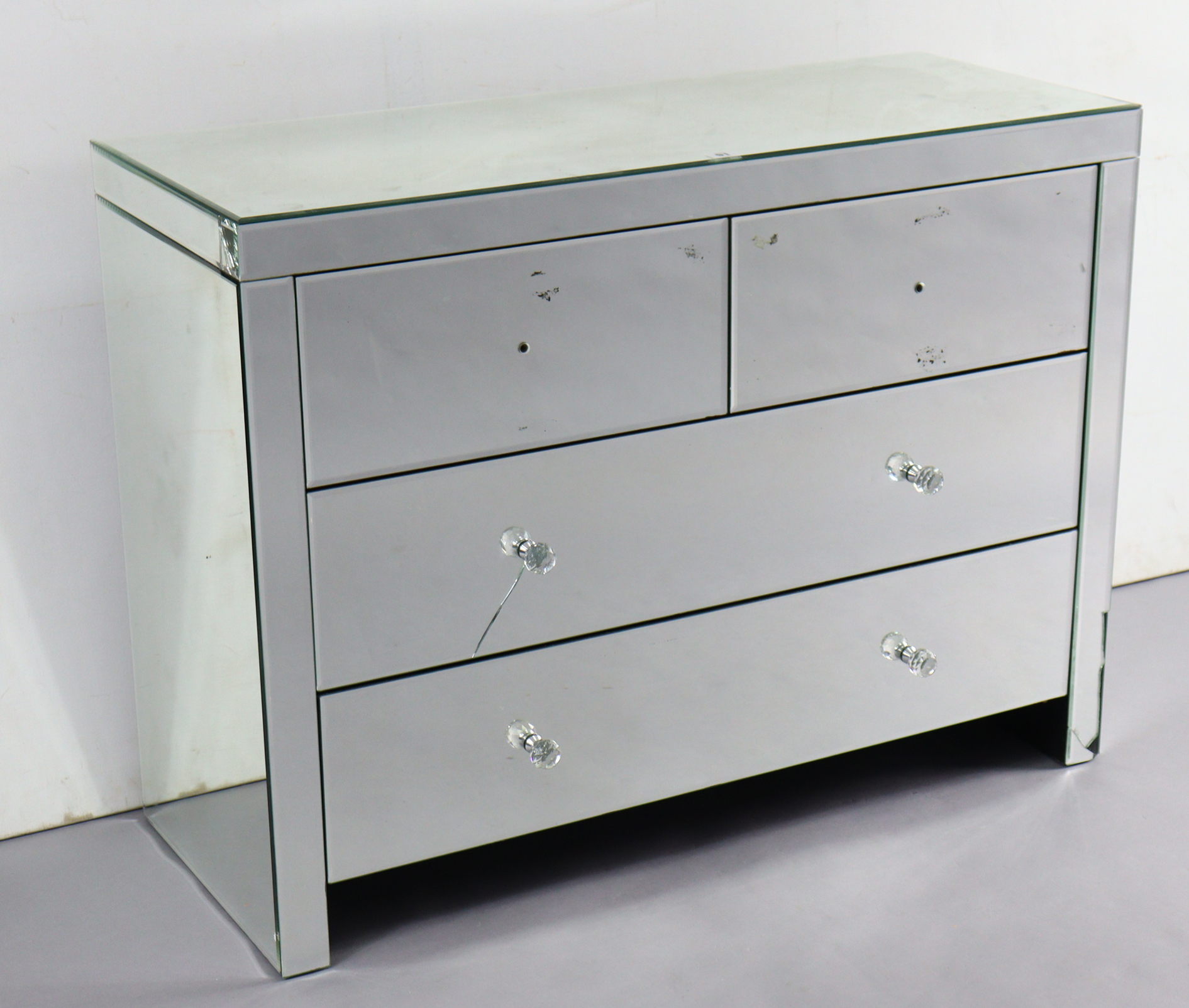 A mirrored dwarf chest fitted two short & two long drawers with faceted knob handles, 39¼” wide x