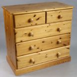 A pine chest fitted two short & three long drawers with turned knob handles, & on a plinth base,