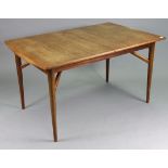 A 1960’s Everest teak extending dining table with a rectangular top, centre leaf, & on four round
