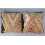 A pair of kilim scatter cushions with multicoloured geometric designs, each 17” square.