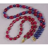A necklace of alternating oval facetted ruby & round sapphire beads, 18¾”; & another of oval