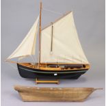 A painted wooden pond yacht with sails & stand, 29” wide x 28¾” high; & a wooden model ships hull,