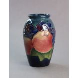 A Moorcroft pottery “pomegranate” vase of slender ovoid shape & blue ground, 4” high x 2½” wide,