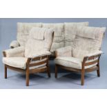 An Ercol elm four-piece lounge suite comprising of a three-seater settee with loose cushions to