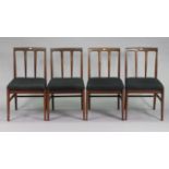 A set of four teak rail-back dining chairs with padded seats, & on square tapered legs with plain