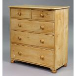 A pine chest fitted two short and three long graduated drawers with turned knob handles, & on bun