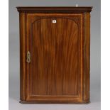 A 19th century inlaid-mahogany hanging corner cupboard fitted two shelves enclosed by a panel
