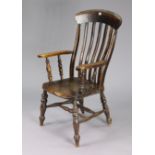 A Victorian lath-back elbow chair with a hard seat & on turned legs with spindle stretchers.