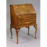 A small burr-walnut bureau with a fitted interior enclosed by a fall-front above two long