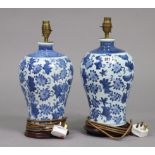 A pair of blue and white table lamp bases of bulbous form and with foliate decoration, 13” high,