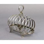 A late Victorian silver large toast rack of six oval divisions, with centre ring handle & on four