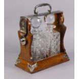 A late Victorian “Betjeman’s Patent” oak tantalus with silver-plated mounts, fitted two cut-glass