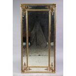 A large reproduction gilt-frame rectangular wall mirror with central bevelled plate in a mirrored