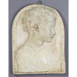 A cast plaster rectangular plaque depicting a Donatello-style bas relief portrait of a young male,