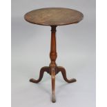 A Georgian oak tripod table with fixed circular top on a slender vase-turned centre column &