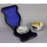 An Edwardian silver butter dish of scallop shell design, with three ball feet, Birmingham 1904 by W.