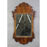 A George III style walnut wall mirror in fret-carved frame with cushion moulding & gilt inner