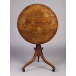 A George IV mahogany tripod table with circular tilt-top on a vase-turned centre column with three