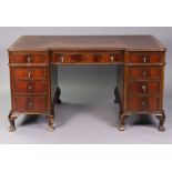 An early 20th century Continental mahogany pedestal desk, with moulded edge to the shaped