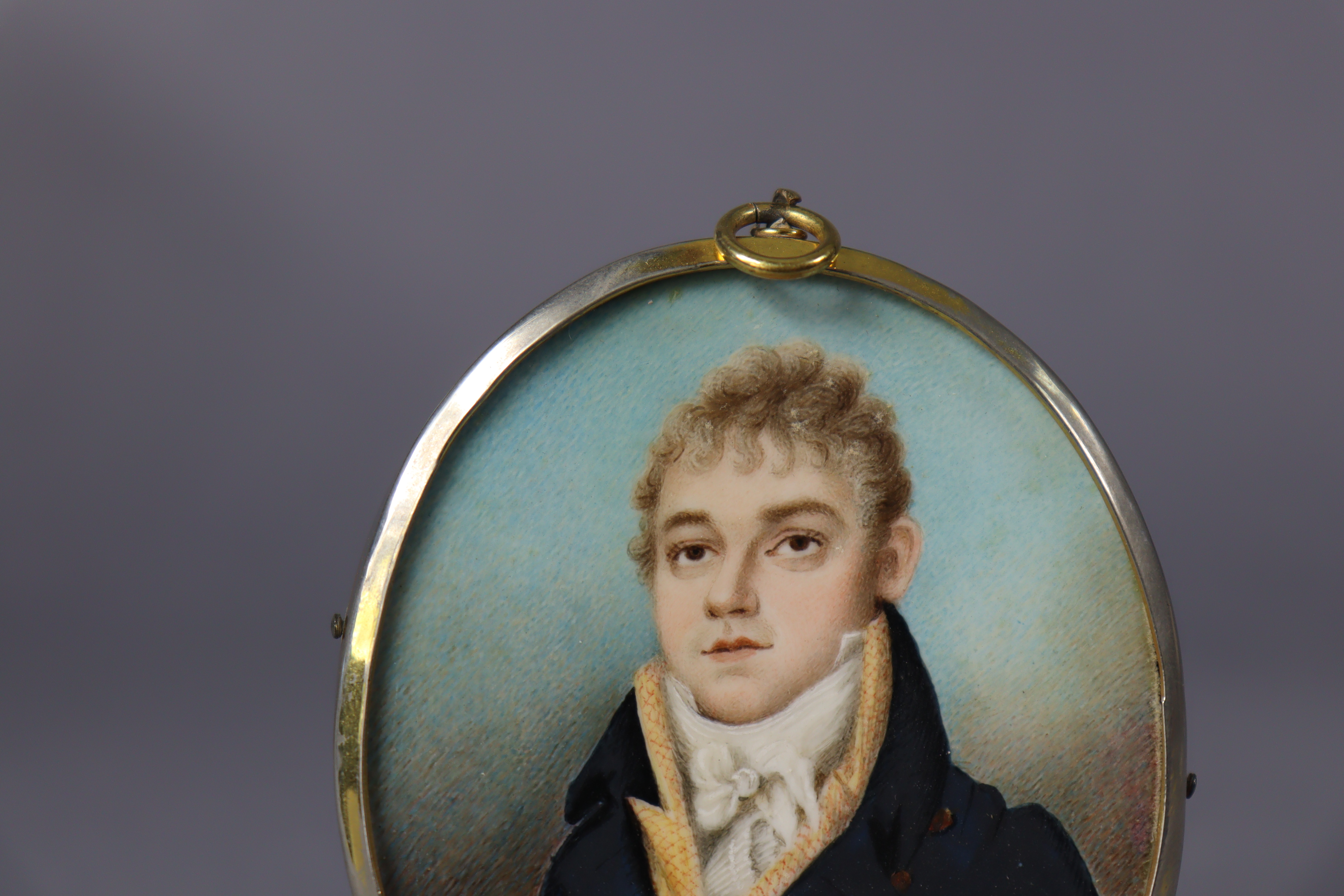 An early 19th century portrait miniature of a gentleman, wearing navy jacket with white cravat, - Image 2 of 3