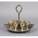 A Victorian silver egg cruet, the six goblet-shaped egg cups with beaded rims, on boat-shaped