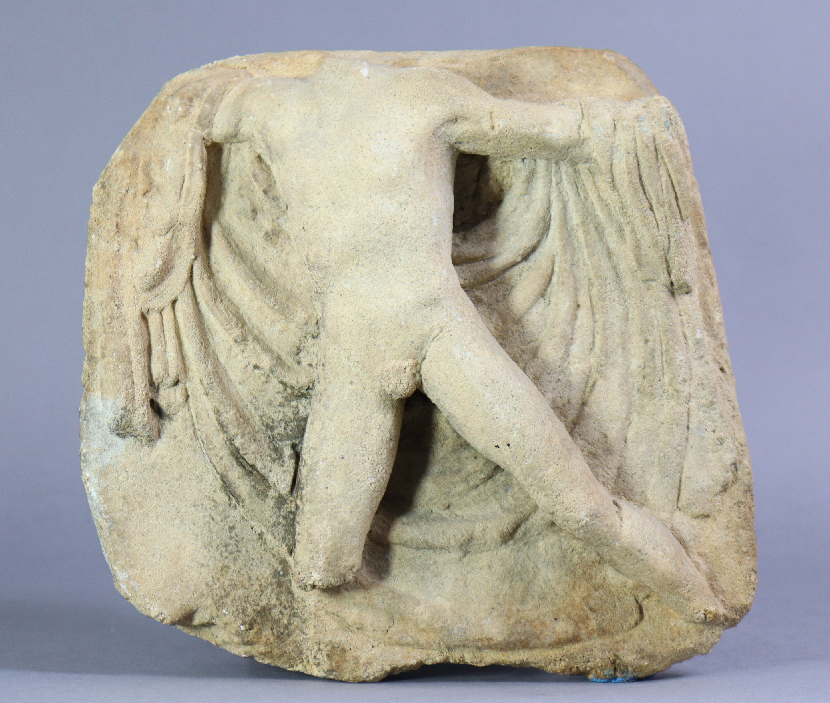 A Roman-style stone relief fragment, depicting a male torso, 9” x 10”.