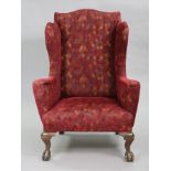 A Victorian mahogany wing-back armchair, upholstered geometric fabric, on carved claw-&-ball feet,