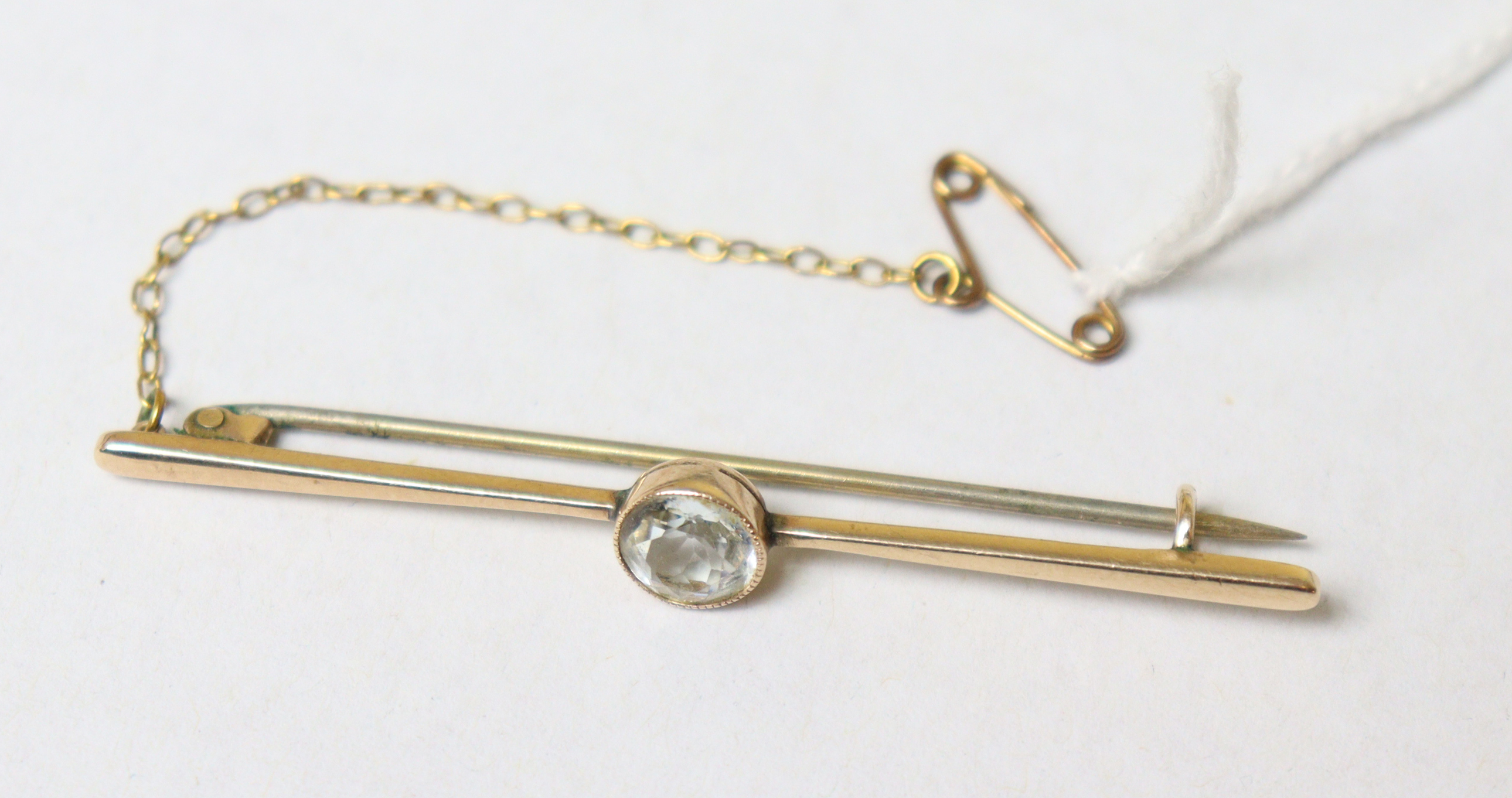 A 9ct gold bar brooch set round-cut white stone, 2¼” long (2.9g), with safety chain. - Image 2 of 2