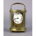 A late 19th century carriage clock in oval brass glazed case, the 1¾” oval white enamel dial with