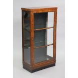 An early 20th century walnut display cabinet, fitted two glass shelves enclosed by a glazed panel