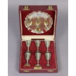 An Elizabeth II silver liqueur set comprising a 6” diam. tray & six 2¾” goblets, Birmingham 1975, by