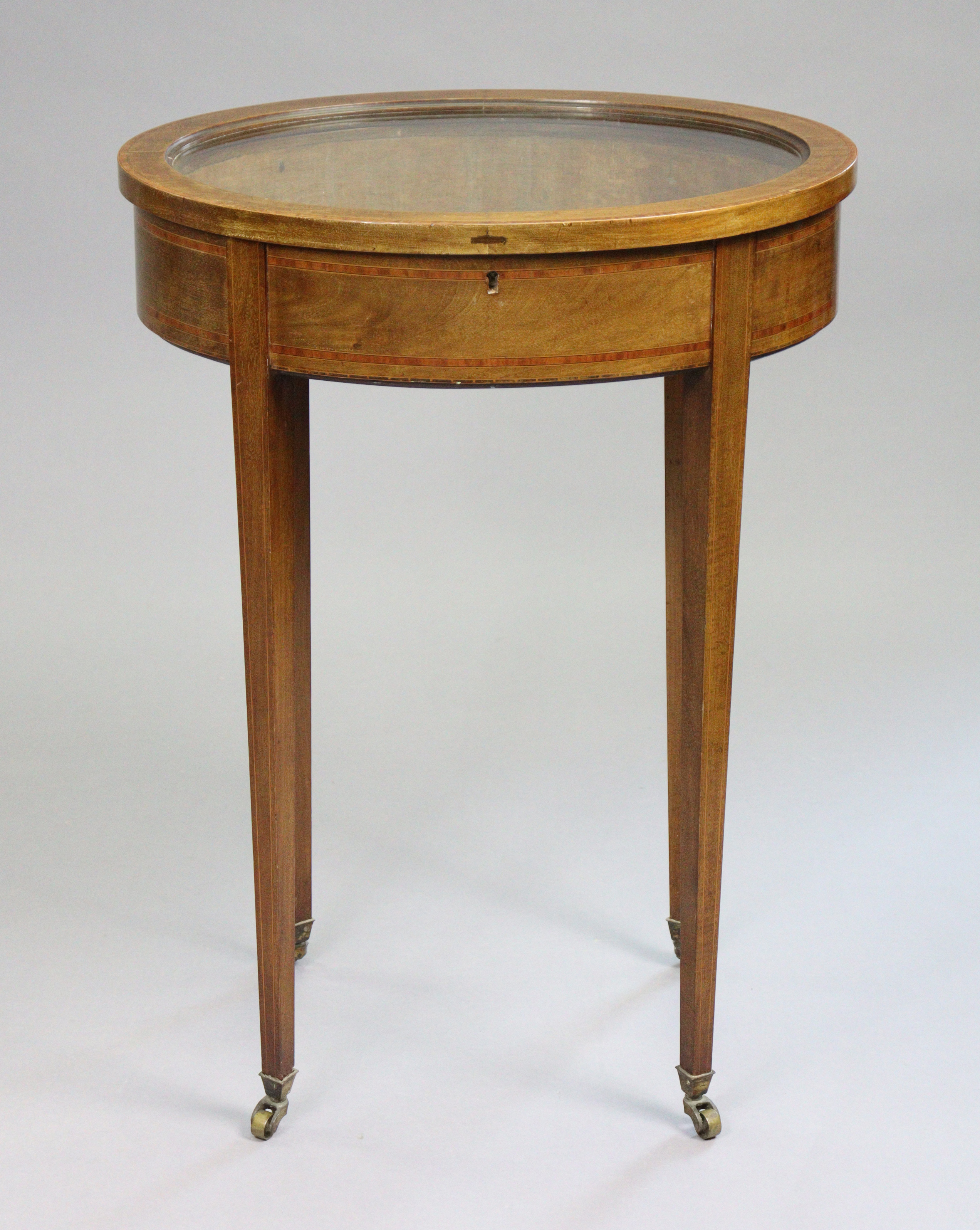 A 19th century inlaid mahogany oval bijouterie table with old-gold velour lined interior enclosed by