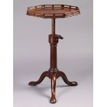 A GEORGE II MAHOGANY ADJUSTABLE TRIPOD TABLE, the octagonal top with pierced gallery, on gun-