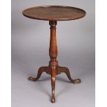 A Georgian mahogany tripod table with moulded edge to the fixed circular top, on vase-turned