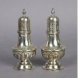 A pair of Victorian silver pepper pots of baluster shape, each with embossed