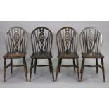 A set of four oak wheel-back kitchen chairs with hard seats, & on turned legs with spindle