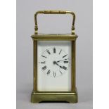 A French large brass cased carriage timepiece with black roman numerals to the white enamel dial (