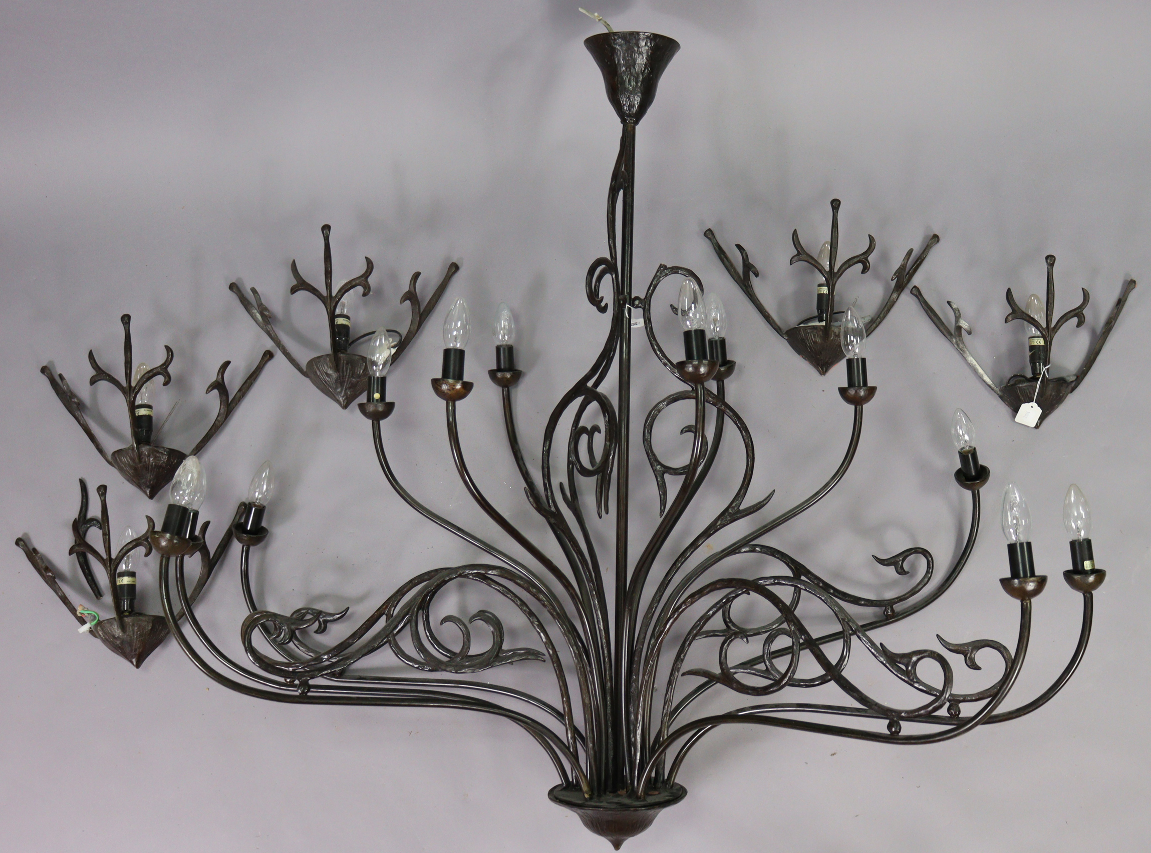 A black wrought-metal twelve-branch chandelier, 49” wide x 45” high; & a matching set of five wall