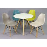 A retro-style kitchen table having a white-finish circular top, & on four round tapered legs, 31¼”